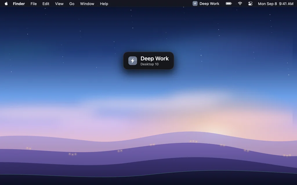 A dark rounded tag in the middle of the screen with a blue tile, the name Deep Work and Desktop 11 beneath it.